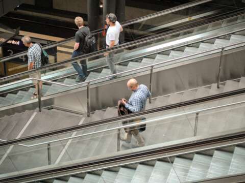 Auf die Treppe, fertig, los: Ein Mann geht zwischen zwei Rolltreppen die Treppe herunter, während drei andere Rolltreppe fahren