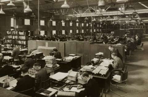 Frauen und Männer in einem Großraumbüro um 1940