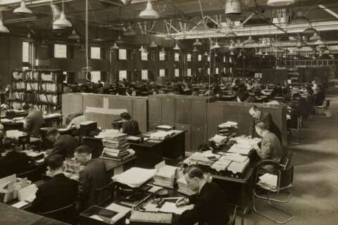 Frauen und Männer in einem Großraumbüro um 1940