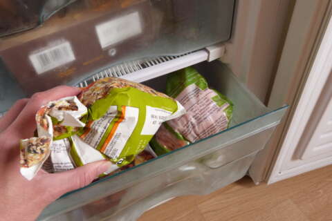 Eine Packung Tiefkühlgemüse wird aus dem Gefirerfach genommen