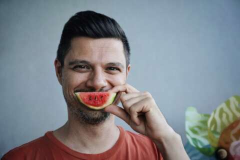 Foodblogs: Ein Mann hält sich eine kleines Stück Wassermelone vor den Mund