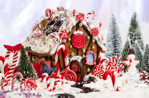 Weniger Zucker: Rotes Lebkuchenhaus mit roten Süssigkeiten