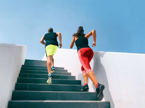 OUTDOOR FITNESS: Läuferpaar rennt eine Treppe hinauf